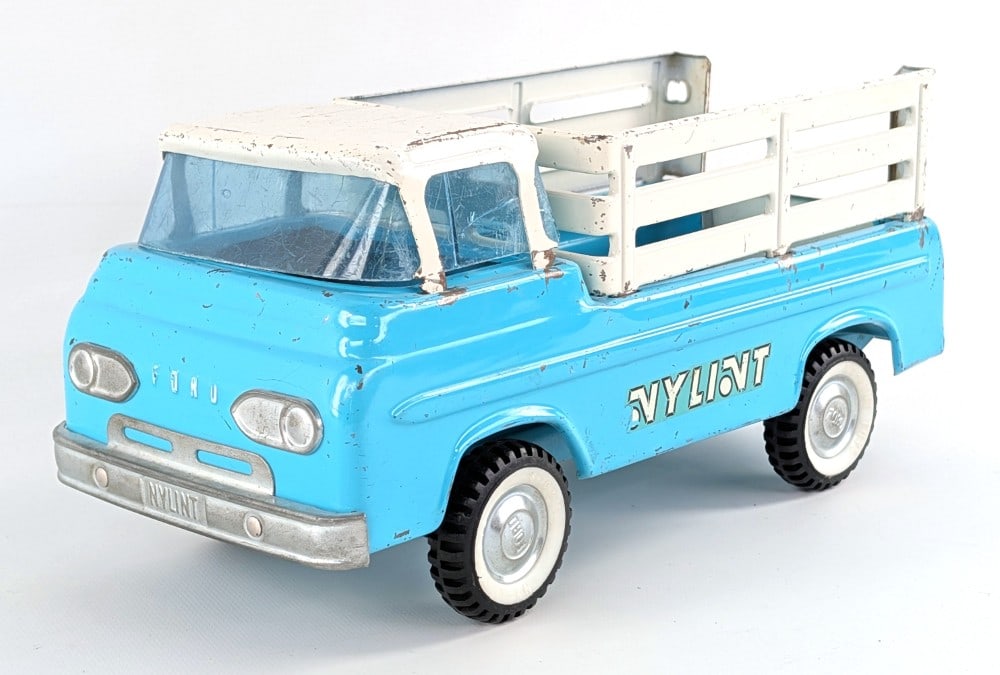 Original Nylint Stake Bed Truck: Original Nylint Ford Econoline stake bed truck. The truck has a crack in the windshield and is missing the rear gate. It shows paint loss and wear from play and age. Measures approximately 11" long.