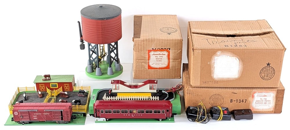 American Flyer 771 Operating Stock Yard, 766 Animated Station, 596 Water Tank: American Flyer No. 771 operating stock yard, No. 766 animated station platform and car, and No. 596 water tank. All come with original boxes that show wear from age / storage. All accessories appear t