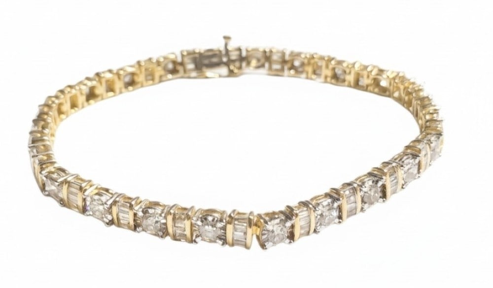 14kt Yellow and White Gold Diamond Tennis Bracelet: The bracelet has 132 diamonds - (22) diamonds are each set in a 10kt white gold illusion style head with four prongs. (110) baguette diamonds are channel set in 22 groups of 5.? Total diamond weight