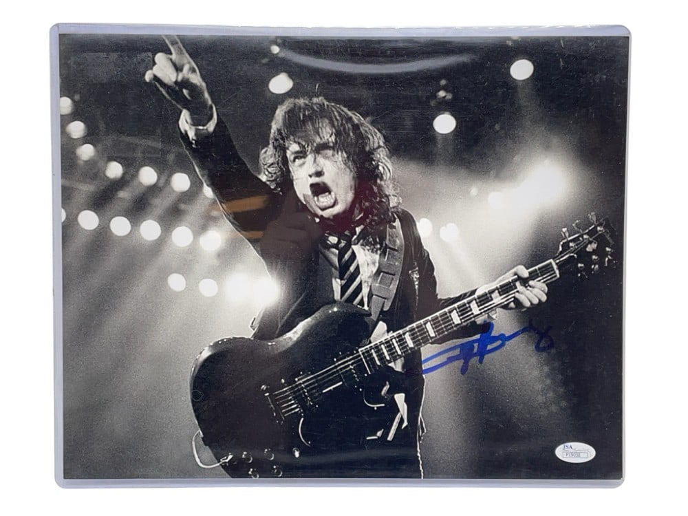 Angus Young AC/DC Signed Photograph: Angus Young AC/DC Signed Photograph. The Infamous Guitarist, Signed in Blue Marker and JSA Authenticated. Measures 11? x 14