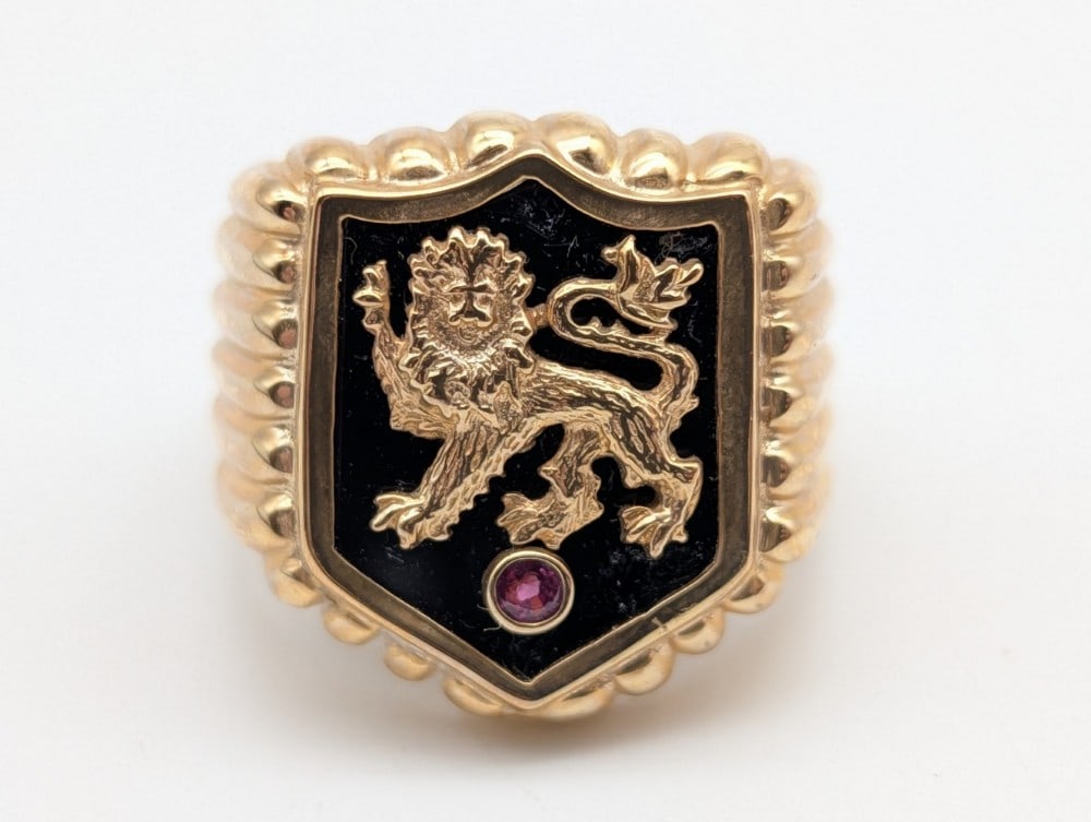 Lion Crest 10k Yellow Gold Mens Ring: Lion Crest 10k Yellow Gold Mens Ring. Includes what appears to be a garnet stone on the front. Ring size 10-1/2. Total weight 16.1g.