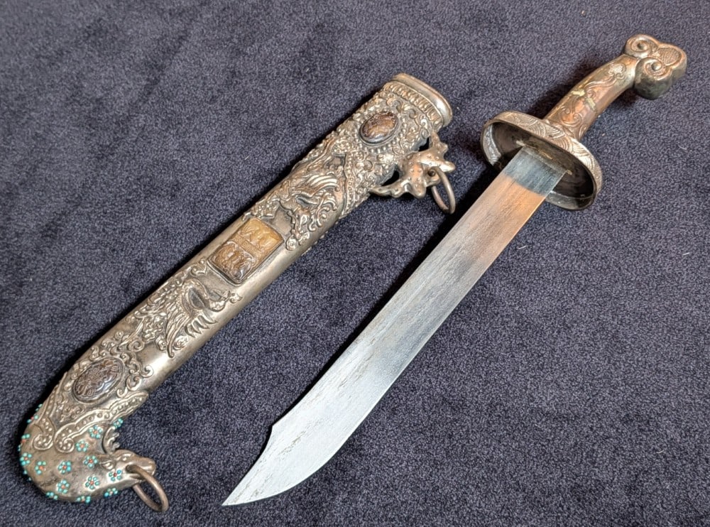 Chinese Tibetan Decorative Swords & Belt: Chinese Tibetan Decorative Swords & Belt. Both swords feature stamped metal designs and the handles and scabbards. The belt features a large cast metal center piece and matching smaller discs that go