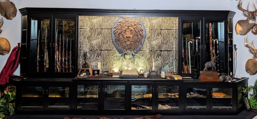 Black & Zebra Print Magnetic Lock Gun Cabinet / Display Case: Black & Zebra Print Magnetic Lock Gun Cabinet / Display Case. Each case holds up to 12 long guns with beveled glass windows for displays. Does come with an official magnet key. Cabinets are in very ni