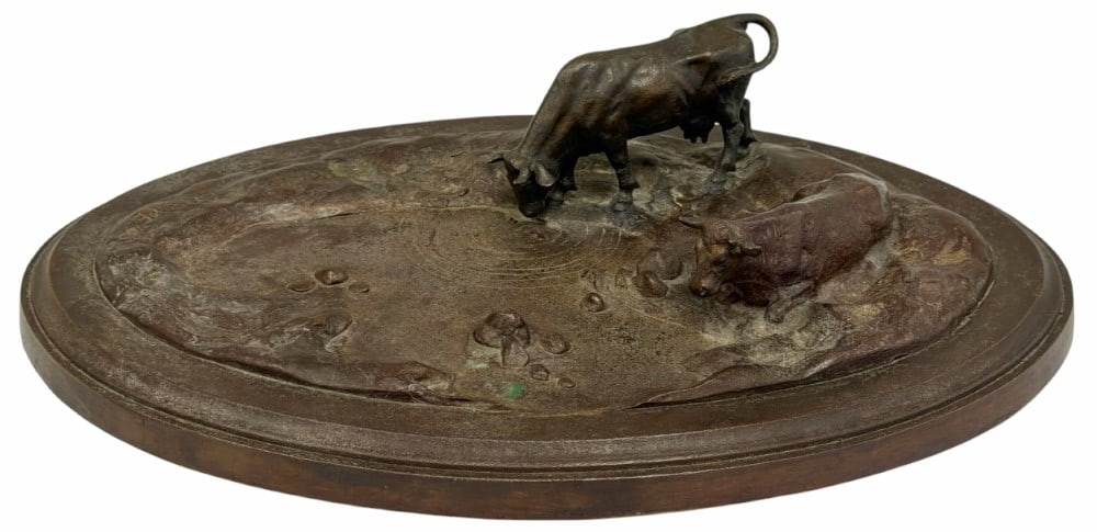 Antoine-Louis Barye Oval Steer Bronze Sculpture: Antoine-Louis Barye Oval Steer Bronze Sculpture. This oval sculpture depicts two steers, one laying down and the other drinking water from a pond or puddle. It is signed by artist Barye. Appears to be