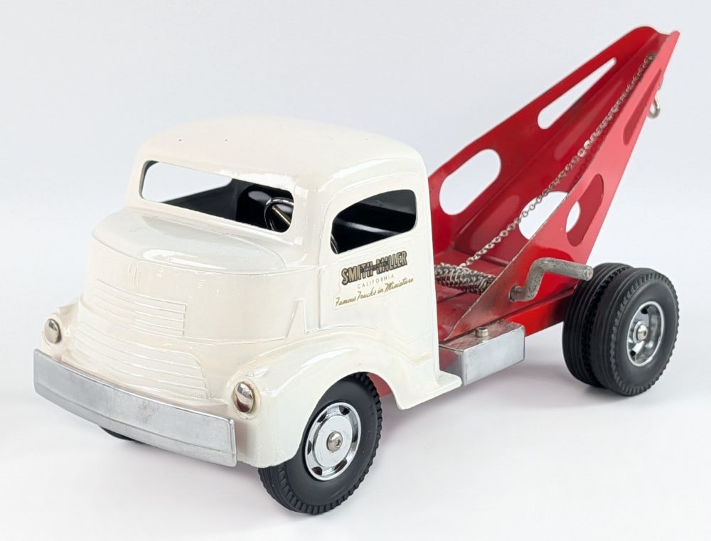 Custom Smith Miller GMC Tow Truck: Custom Smith Miller GMC tow truck. The truck has an amateur paint job. The truck shows some small paint chips and scratches. Displays well with chrome wheels. Measures approximately 14" long.