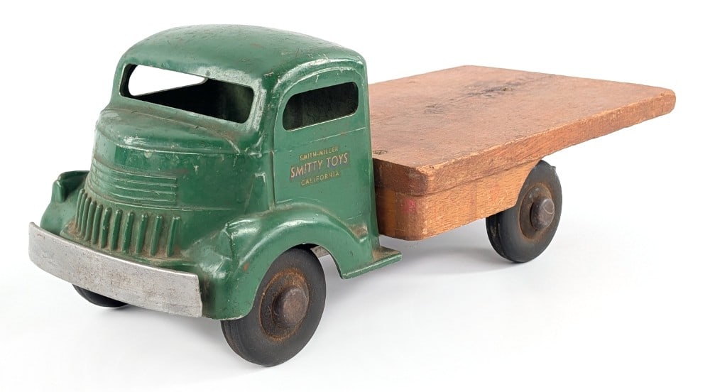 Smith Miller Chevy Flatbed Truck: Smith Miller Smitty Toys Chevy flatbed truck. The truck has a wood flatbed. Original condition showing paint loss and wear from play / age. Measures approximately 14" long.