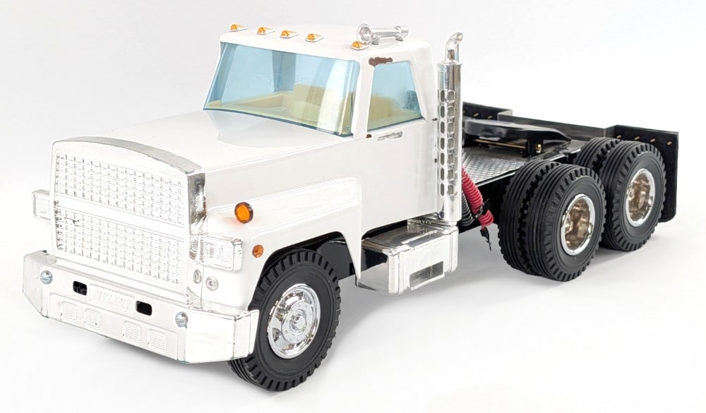 M&J Custom Nylint Semi Truck: M and J custom Nylint semi truck. The truck has custom wheels, mudflaps, and hoses. The truck had mirrors at one time that are missing. Measures approximately 15" long.