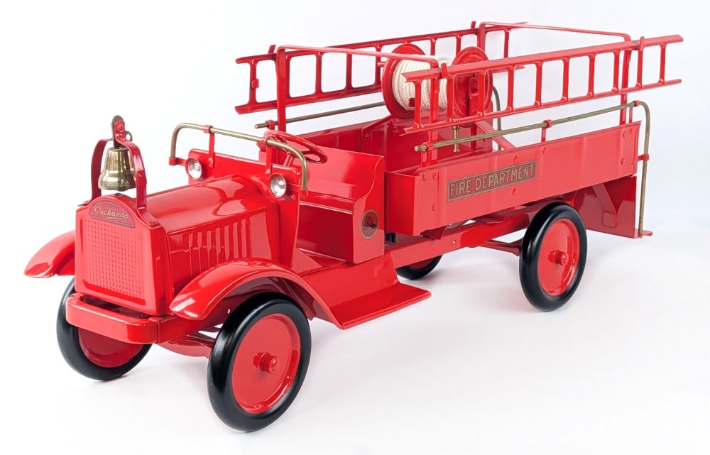 Restored Keystone Packard Fire Department Ladder Truck: Professionally restored Keystone Packard fire department ladder truck. The truck is in excellent condition overall. Displays well with two metal ladders, bell, and hose reel. Measures approximately 27