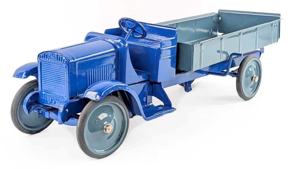 Restored Steelcraft GMC Dump Truck: Restored Steelcraft GMC dump truck. The truck has a blue open cab with gray dump bed. The truck has an average restoration with some pitting and age wear showing mostly in the bed. Measures approximat