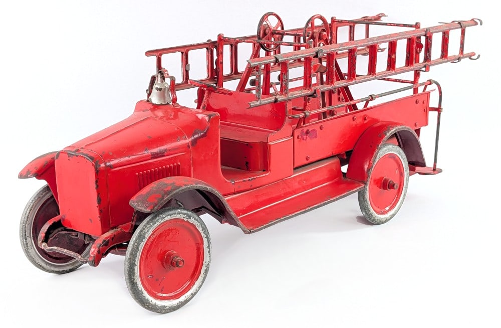 Buddy L Hook & Ladder Fire Truck: Buddy L hook & ladder fire truck. The truck is missing the winch and hose. The truck has an old overpaint with paint loss, dents, and wear from play and age. Measures approximately 25" long.