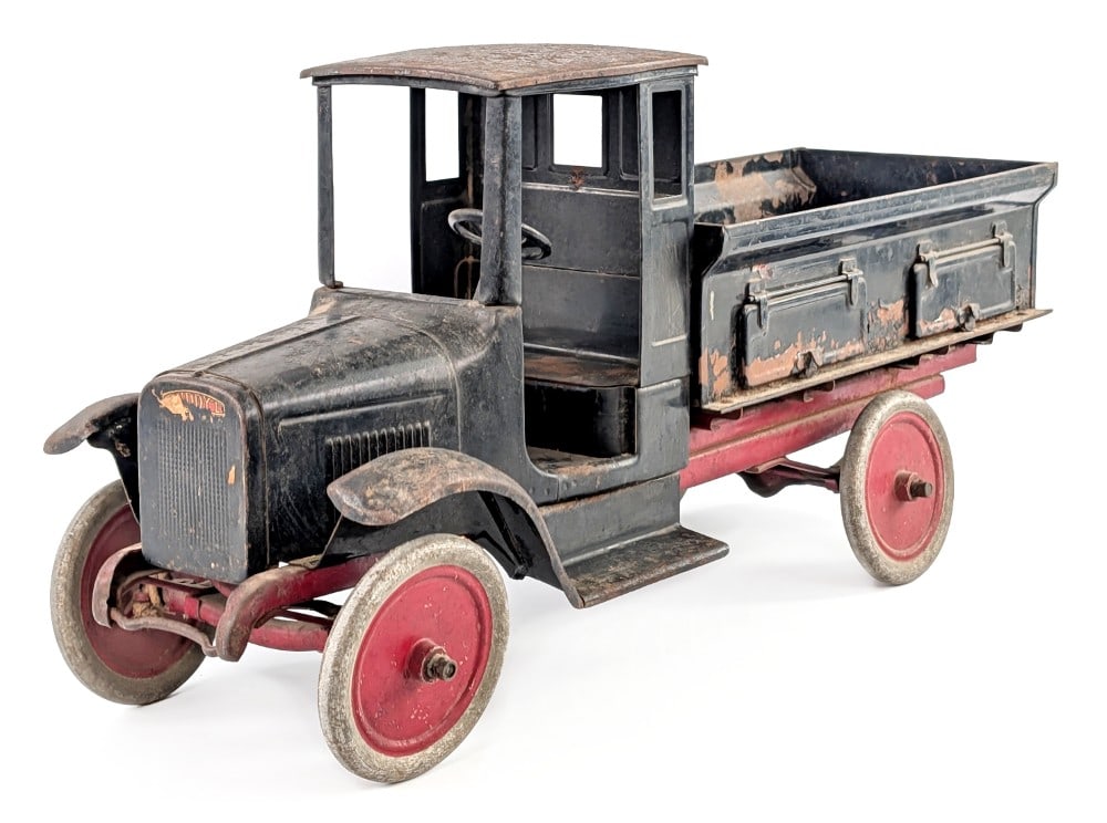Buddy L Sand & Gravel Truck: Buddy L sand and gravel truck. The truck appears to be original with surface rust, paint loss, and wear from play and age. Some of the Buddy L decals are still visible. The truck would benefit from a 