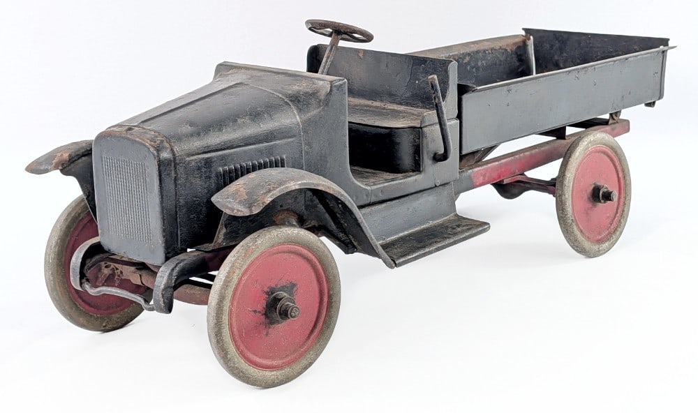Buddy L Hydraulic Dump Truck: Buddy L hydraulic dump truck. The hydraulic dump still works. The truck has an old overpaint with surface rust and age wear showing. Measures approximately 24" long.