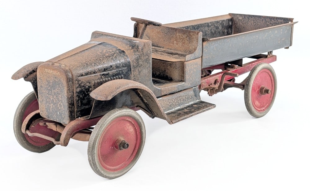Buddy L Chain Lift Dump Truck: Original Buddy L chain lift dump truck. The truck has surface rust, paint loss, and wear from age. It still has the Buddy L decal below the steering wheel. The truck was dusted off, but will probably 