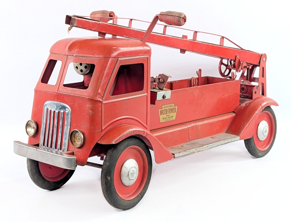 Keystone Ride 'Em Water Tower Fire Truck: Keystone Ride 'Em water tower fire truck with real pump. The truck is missing the seat, ladders, and nozzle for the water tower. The truck has a real pump and siren. The truck shows paint loss and wea
