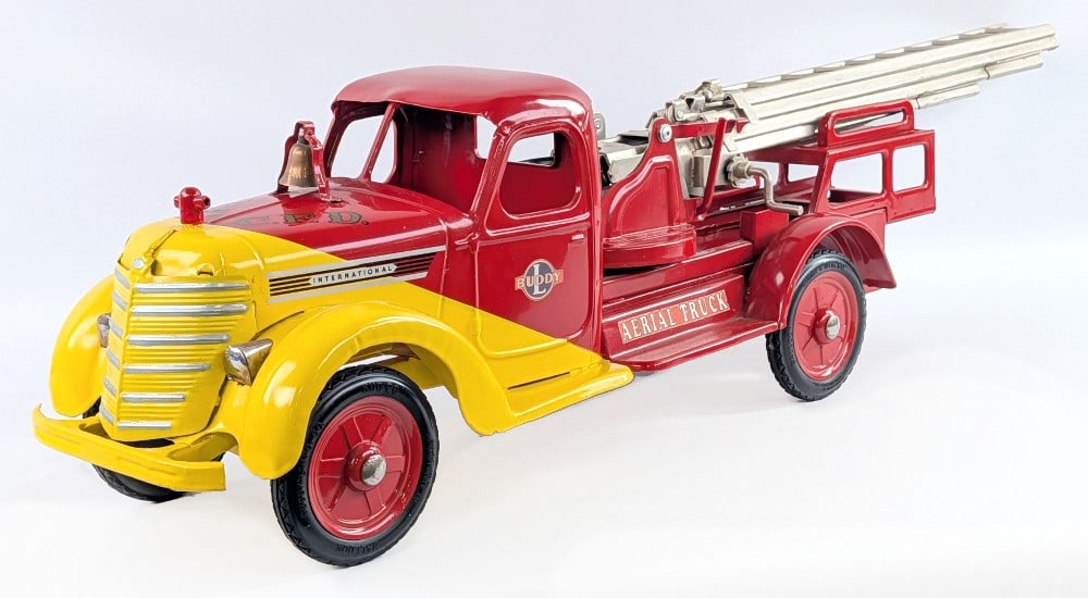 Restored 1938 Buddy L International Aerial Ladder Fire Truck: Restored 1938 Buddy L aerial ladder fire truck. The truck is dusty / dirty from display. The metal piece the bell is mounted on is loose on the one end. The hydraulic for the ladder doesn't work very 