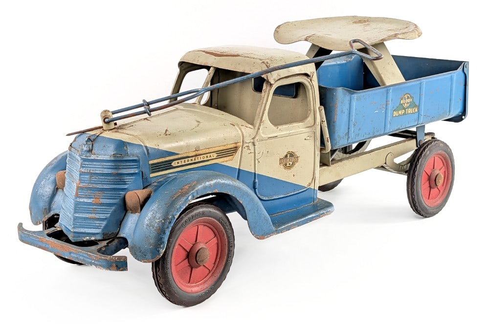1938 Buddy L International Hydraulic Dump Truck: 1938 Buddy L International ride on hydraulic dump truck. The steering handle needs adjusted to steer the wheels. The truck is original with paint loss and wear from play and age. The roof is starting 