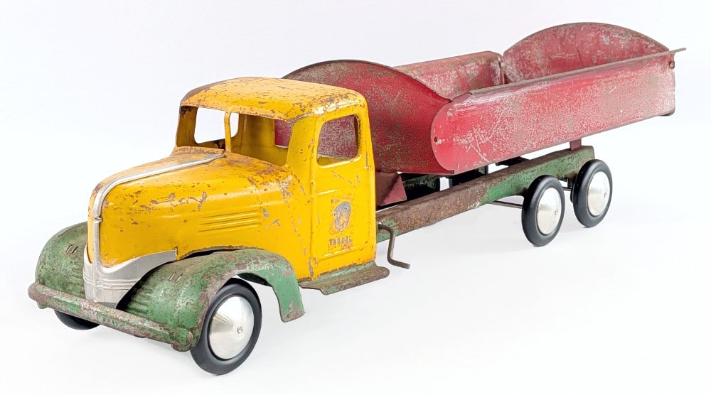 Turner Dump Truck: Turner dump truck. The wheels look to be replaced. The truck is missing the headlights and the bed doesn't sit straight. The truck shows paint loss, surface rust, and wear from age. Measures approxima