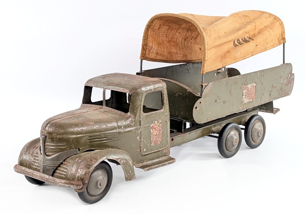 Turner Army Truck: Original Turner army truck. The truck is missing the headlights and hood trim piece. The truck shows decal loss, paint loss, and surface rust from play and age. Measures approximately 25" long. *From 
