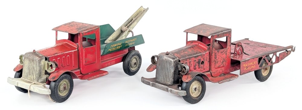 Metalcraft Tow Truck and Machinery Hauler: Metalcraft wrecker tow truck and Metalcraft machinery hauling truck. The machinery hauler is missing a wheel, rear ramp, and winch cable. Both show paint loss and wear from play / age. Each measures a