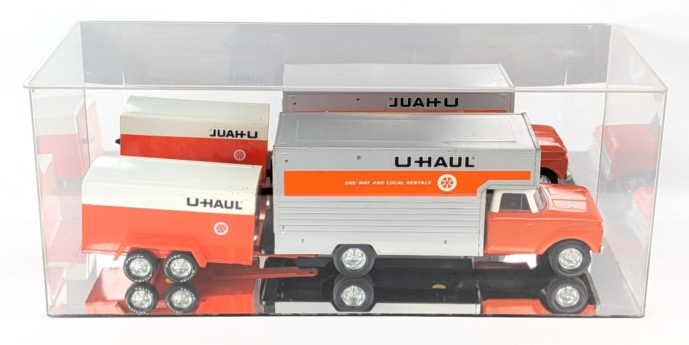 Nylint U-Haul Box Truck with Trailer in Display Case: Original Nylint U-Haul box truck with enclosed trailer. Original condition with paint loss and wear from play and age. Comes with a plastic display case with mirrored back and bottom. The truck and tr