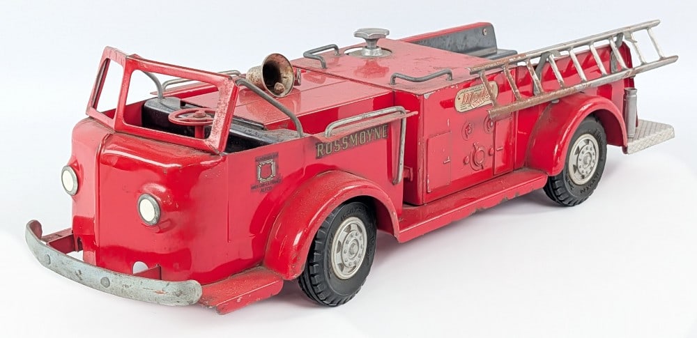 Doepke Rossmoyne Fire Truck - Red: Original Doepke Rossmoyne fire truck. The truck is missing the hose and the fender mounted bell is loose. The toy shows some surface rust and wear from play and age. Measures approximately 18" long.