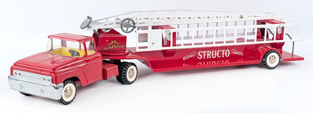 Original Structo Aerial Ladder Fire Truck: Original Structo aerial ladder fire truck. The truck shows some minor play wear, but overall in very good condition. The cranks for the aerial ladder works and it comes with two extension ladders. Mea