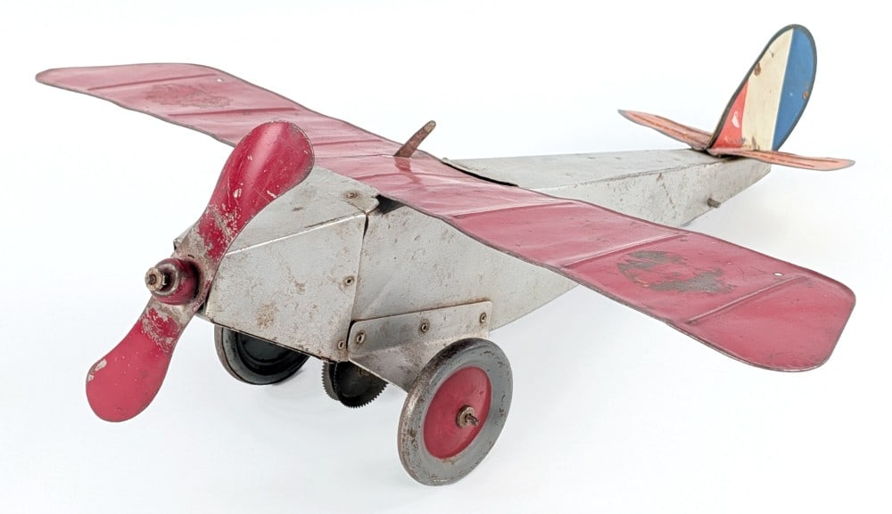 Empire Express Monoplane No. 550: Empire Express Monoplane No. 550. The plane has paint loss, decal loss, and wear from play and age. The propellor spins with the front wheels but the strings needs to be tightened. The wingspan