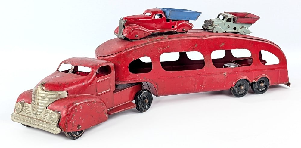 Marx Car Carrier Truck and Dump Trucks: Marx auto transport car carrier truck and three smaller dump trucks. The one gray dump truck has been restored and the other is missing its wheels. The car carrier is missing the ramps. The original t