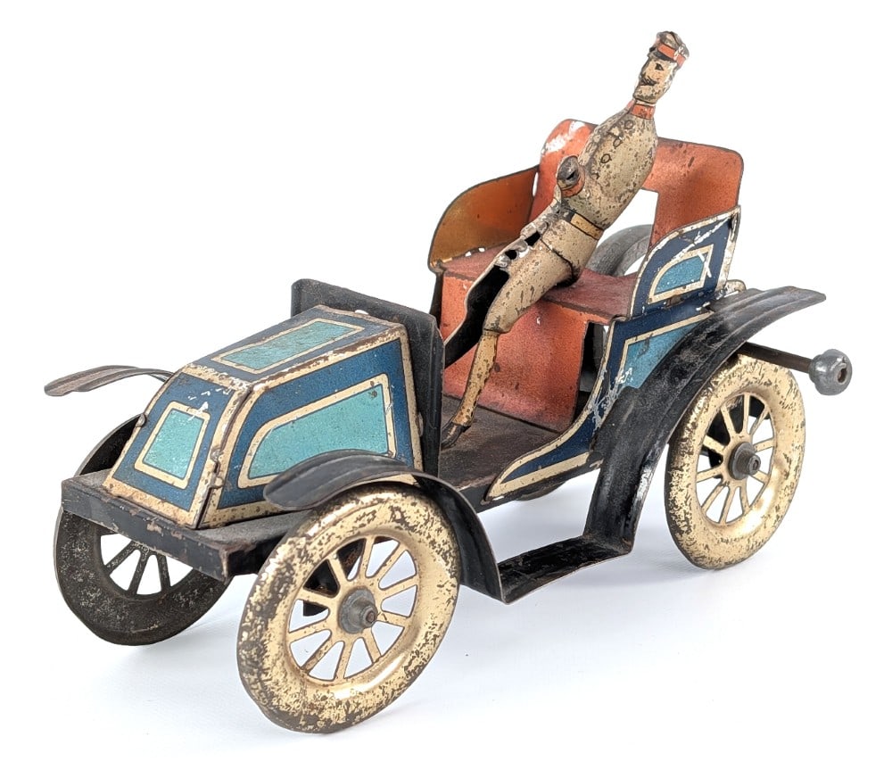 Issmayer Tin Flywheel Driven Runabout: Hard to find German Issmayer tin flywheel driven runabout automobile. The car shows litho loss, discoloration, and wear from age. It is missing the steering wheel. Flywheel mechanism works. Measure ap
