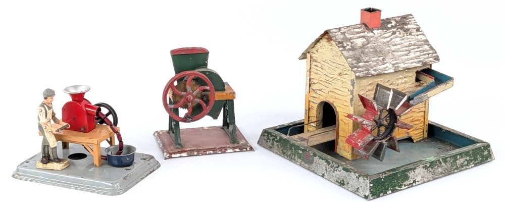 German Steam Toy Accessories: German steam toy accessories. Includes Doll & Cie water mill, Western Germany sausage maker, and grinder / mill. All showing some paint loss and age wear. Nice assortment of steam toy accessories.