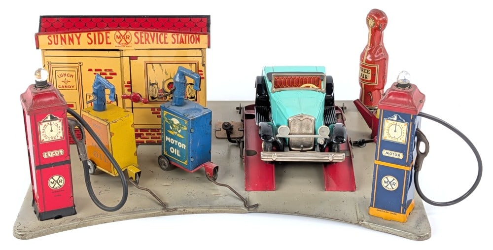 Marx Sunny Side Service Station: Marx Sunny Side Service Station. Comes with a Japan tin car, Marx Lubesters, and fuel can. Showing some loss mostly to the base. Displays well with great colors and graphics. Measures approximately 13
