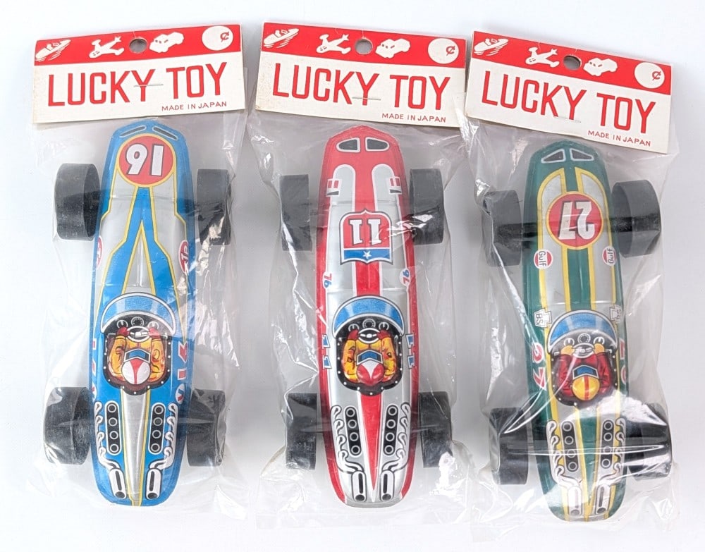 (3) Lucky Toy Japan Tin Racing Cars: (3) Lucky Toy Japan tin litho racers. All are new old stock in the original packaging. Each measures approximately 6-3/4" long.