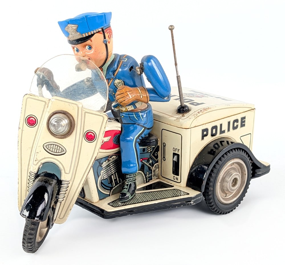 Japan Battery Op. Police Patrol Auto-Tricycle: Japan battery operated Police Patrol auto-tricycle. Has repairs to the arms and minor surface rust. Untested, but battery compartment very clean. Still displays well with great color and graphics.