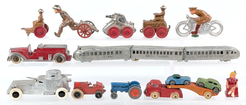 Tootsietoy and Barclay Toys: Includes Barclay car carrier, Barclay soldiers, tanks, Tootsietoy Flyer train, and Tootsietoy fire truck. Some items missing tires. All showing some wear from play and age. The car carrier measures 5"