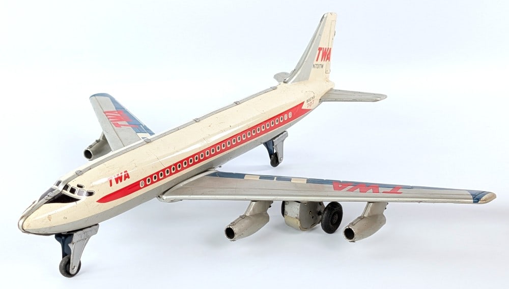 Japan Tin Friction TWA Boeing 707 Airplane: Japan tin friction TWA Boeing 707 airplane. The plane has scratches, scuff marks, and wear from play / age. The friction works. Wingspan measures approximately 18" across.?