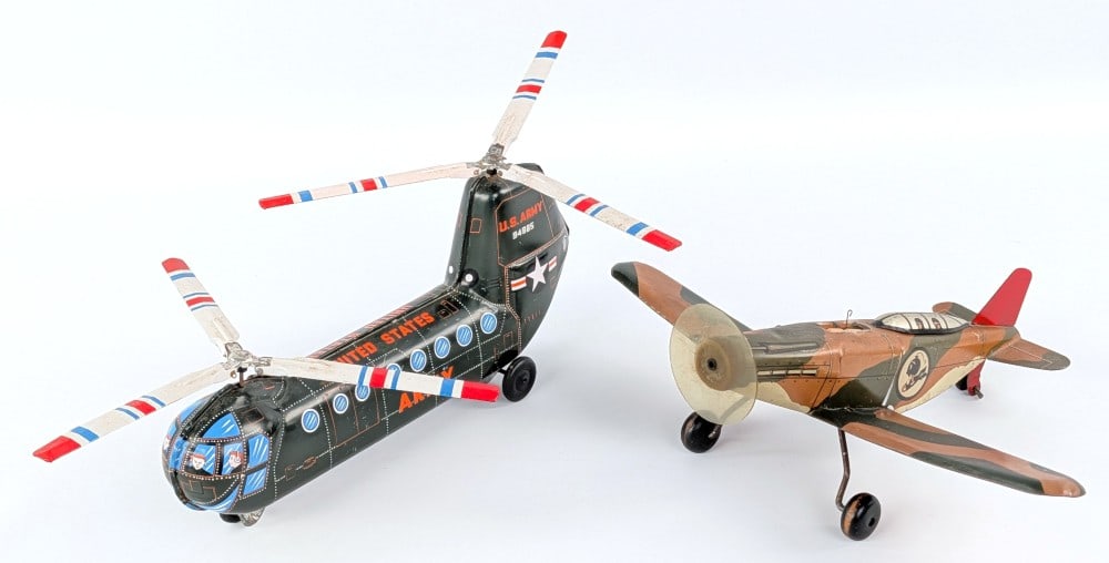 Japan U.S. Army Helicopter and Marx Bombing Plane: Japan tin friction U.S. Army helicopter and Marx bombing plane. The Marx plane comes with two wood shells. Both pieces in working condition. Both showing light play wear. The wingspan on the airplane