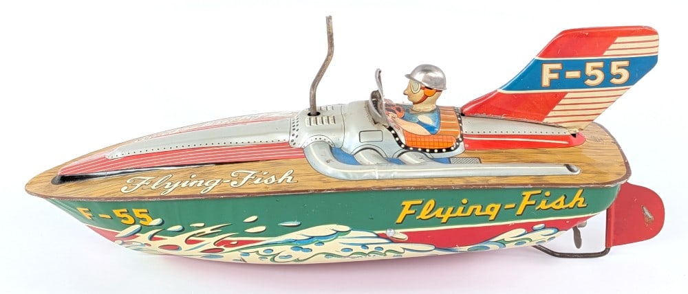 Japan Tin Friction Flying Fish Speed Boat: Japan tin friction Flying Fish speed boat. The friction mechanism works. The boat has some scratches and wear from play / age. Displays well with great color and graphics. Measures approximately 12"