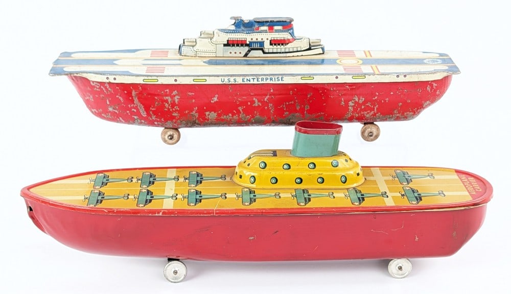 (2) Tin Aircraft Carriers: (2) Tin aircraft carriers. The one is marked Wyandotte and the other is unmarked. Showing paint loss and wear from play / age. Measures approximately 13" long.