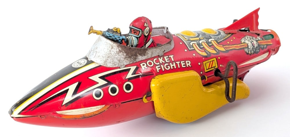 Marx Tin Windup Flash Gordon Rocket Fighter: Marx tin windup Flash Gordon rocket fighter. The windup mechanism works. The toy shows scratches, paint loss, and wear from play and age. Measures approximately 12" long.
