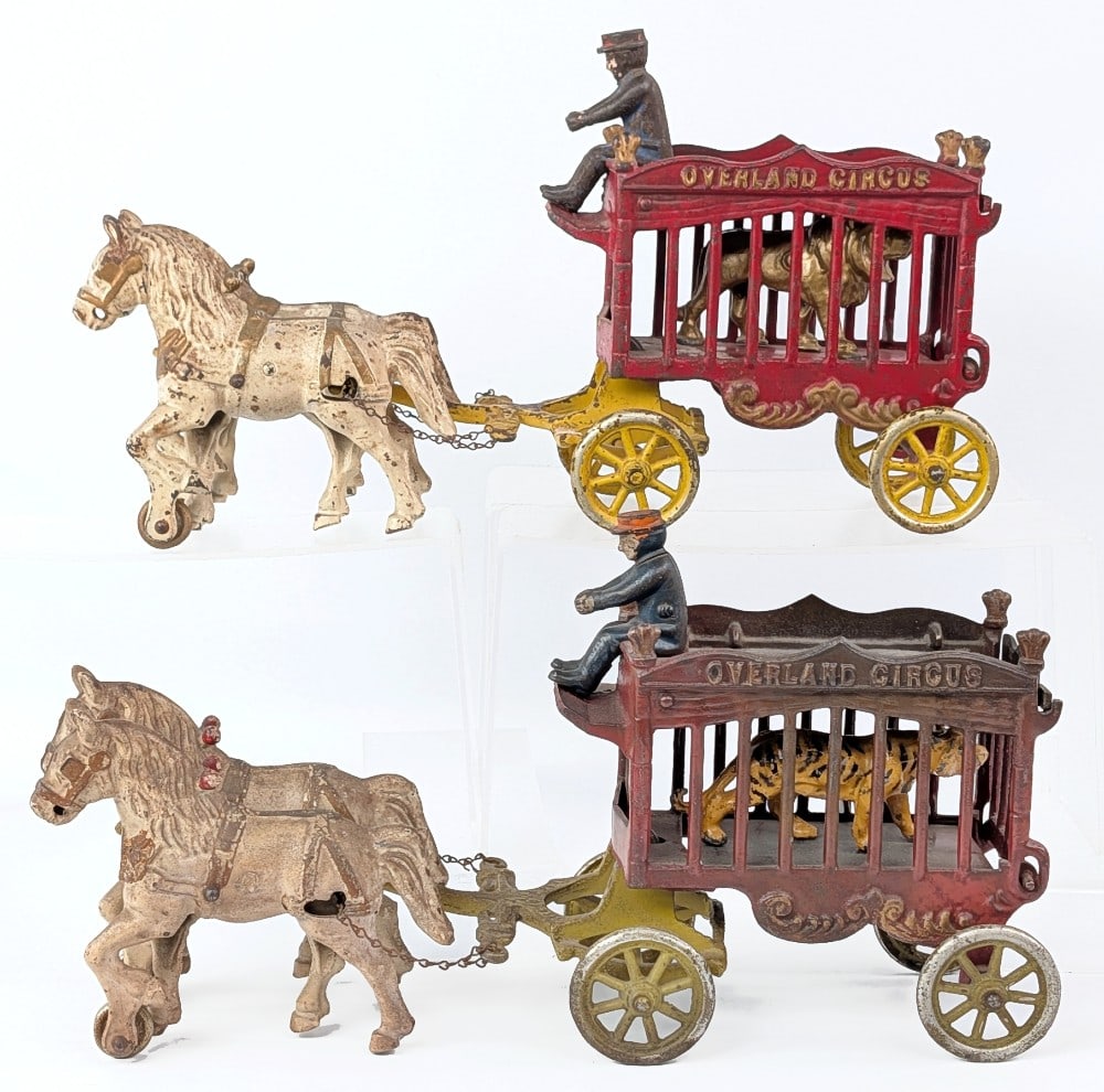 (2) Kenton Cast Iron Horse Drawn Overland Circus Animal Wagons: (2) Kenton cast iron horse drawn Overland Circus wagons. Both would benefit from a detailed cleaning. Comes with lion and tiger animals. Showing paint loss and wear from age. Measures approximately 14