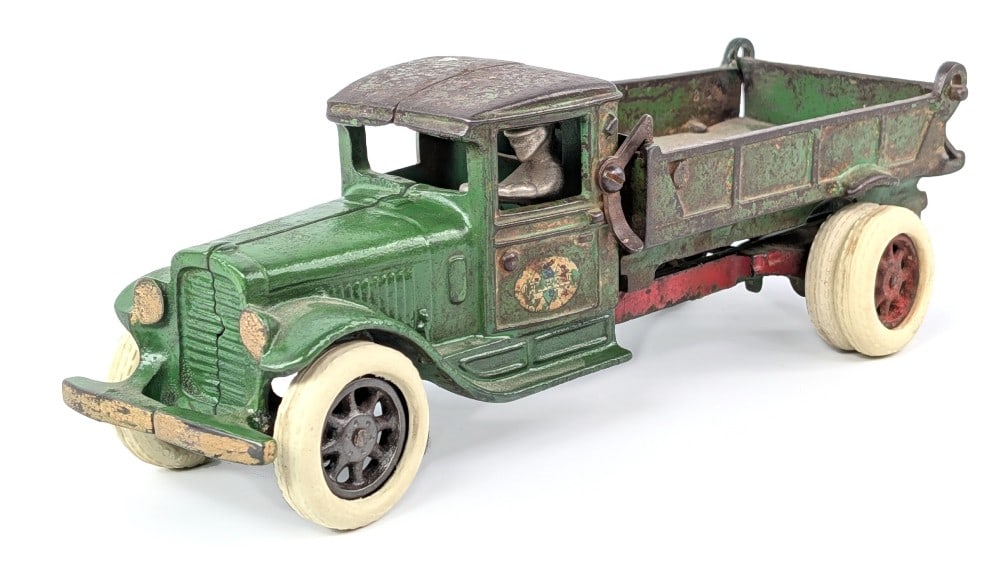 Arcade Cast Iron Green International Dump Truck: Arcade cast iron #236 green International dump truck. The truck has a professional repair to one of the tailgate hinges, old touchup to cab, replaced dump spring, and older replacement tires. Original
