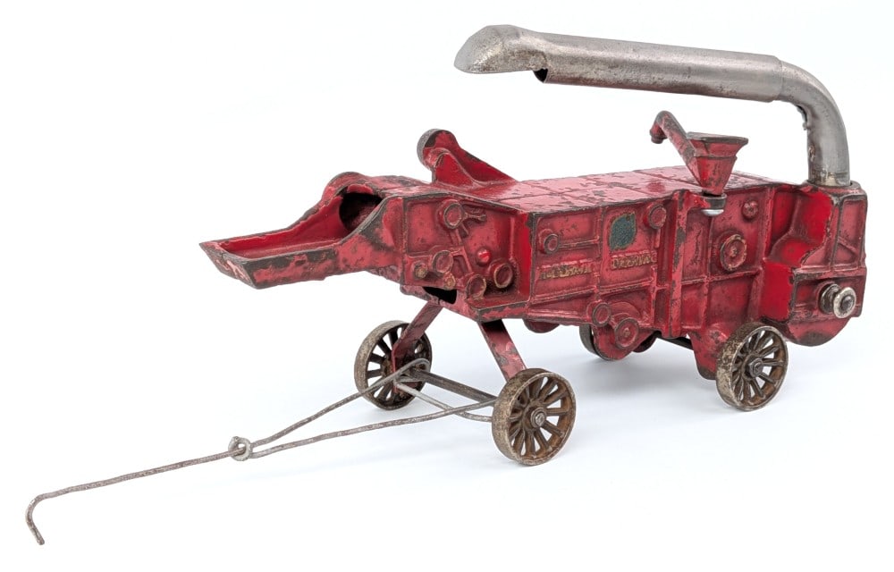 Arcade Cast Iron McCormick-Deering Threshing Machine: Arcade No. 450 cast iron McCormick-Deering thresher. The thresher displays well in red overall with nickeled features. A nice Arcade decal is still present. Measures approximately 9-1/2" long.