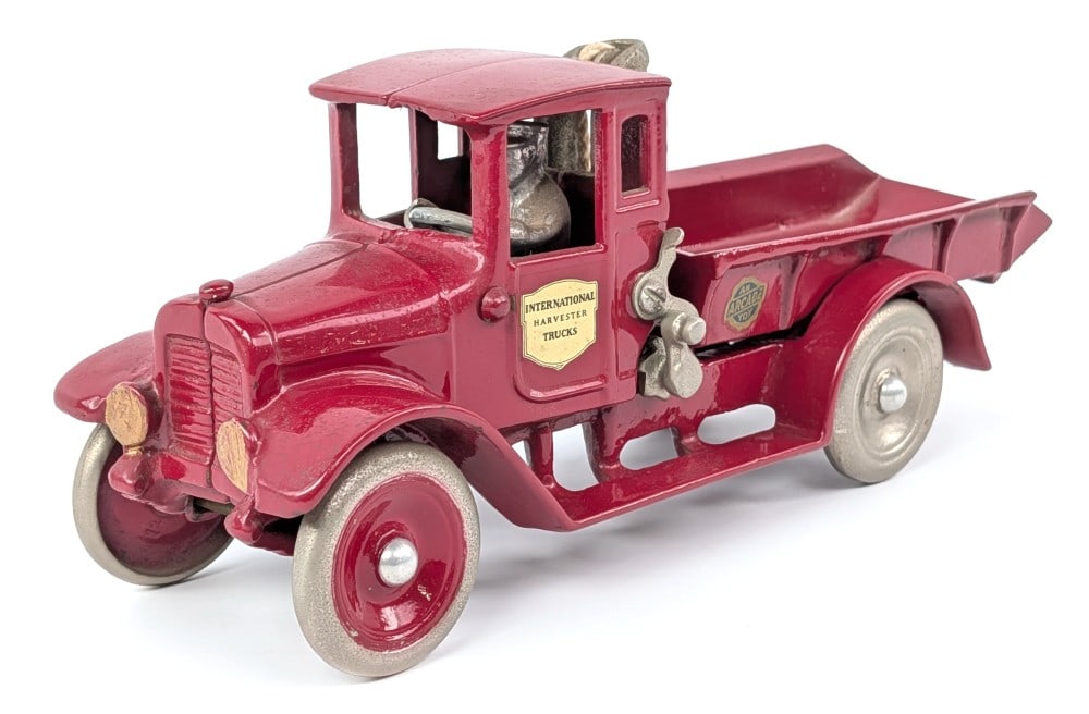 Arcade Cast Iron International Harvester Red Baby Dump Truck: Arcade cast iron International Harvester Red Baby dump truck. The truck has a nice restoration overall with one wheel still needing painted in the center. Dusty from being on display, but overall good