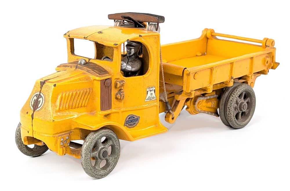 Arcade Cast Iron Mack T-Bar Dump Truck: Arcade cast iron Mack T-Bar dump truck. An older restoration with custom decals applied. It does have a chip on the roof of the cab. Dusty from display and has some paint chips. Measures approximately