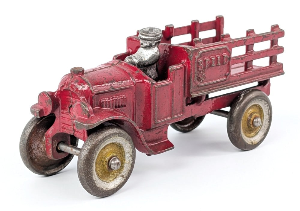 Kenton Cast Iron Speed Stake Bed Truck: Kenton cast iron open cab "Speed" stake bed truck. An older replacement driver. Shows paint loss and wear from play and age. No visible cracks or breaks. Measures approximatley 5-1/2" long.