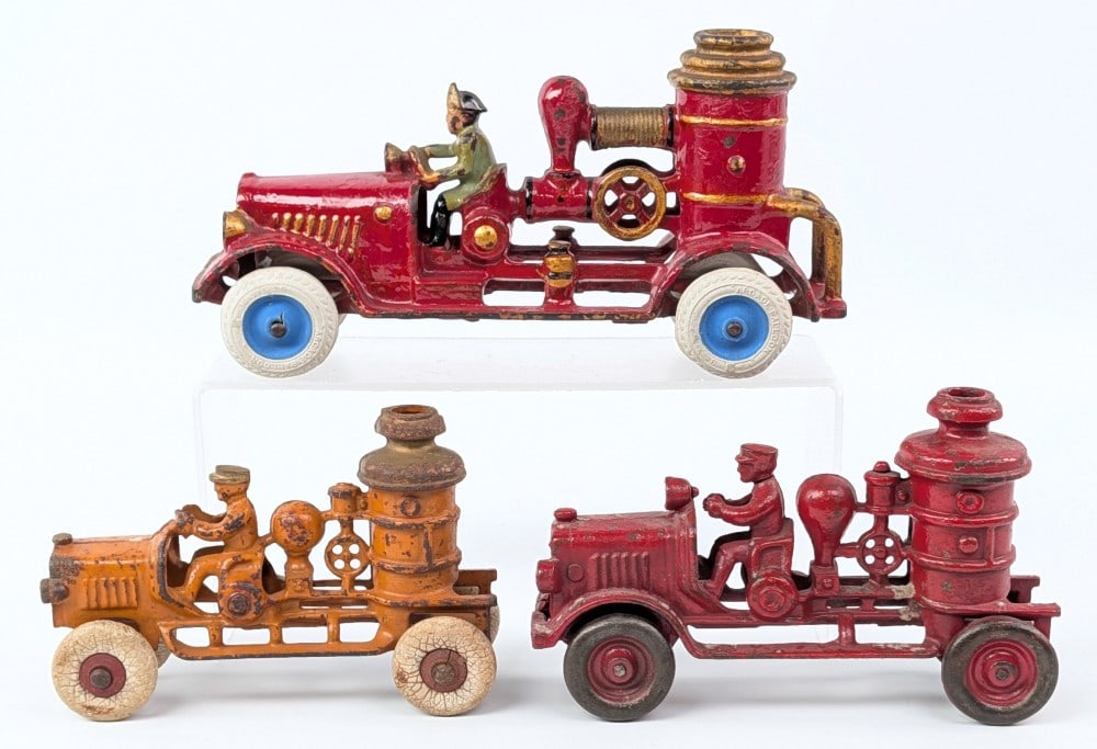 Arcade & Kenton Cast Iron Fire Pumper Trucks: Arcade and Kenton cast iron fire pumper trucks. The largest truck has an older repaint with replaced wheels. The red mid size truck has damage to the front axle housing. All showing some paint loss an