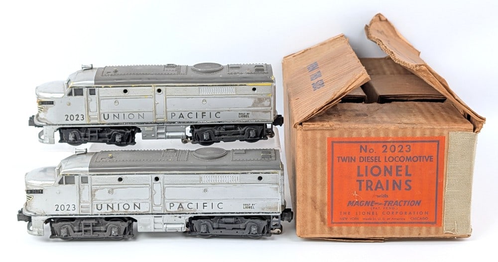 Lionel Union Pacific No. 2023 Twin Diesel Locomotive Set w/ Box: Lionel O Gauge Union Pacific No. 2023 twin diesel locomotive set with the original box. The set shows dust, scuff marks, and paint loss from use and age. The box has writing, discoloration, and wear f