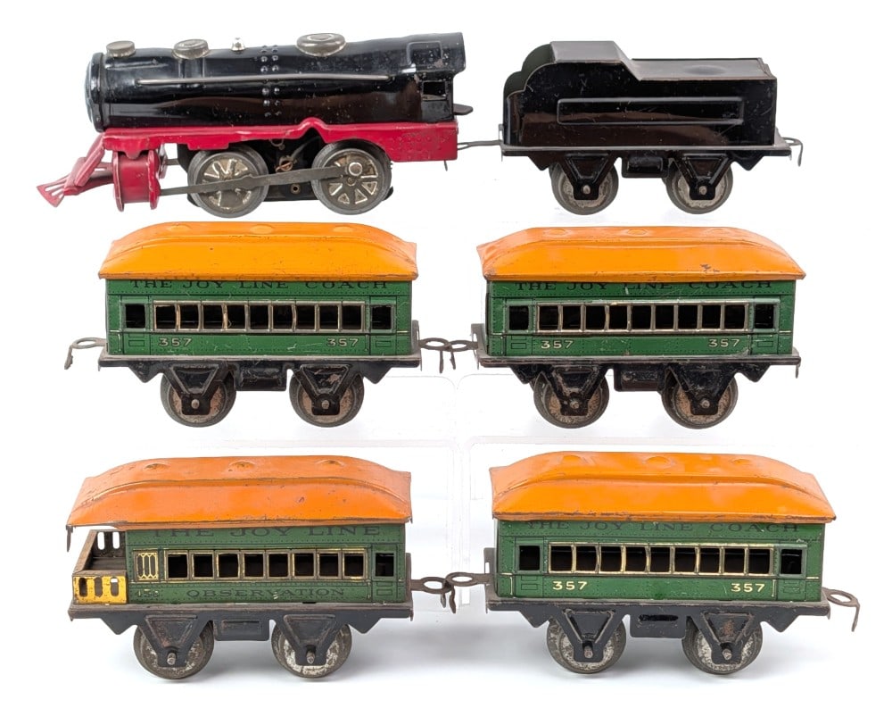 The Joy Line Electric Train Set: The Joy Line electric train set. Includes electric engine with tender and four tinplate passenger cars. Shows scratches and wear from use and age. Touchup to the top of the tender.?