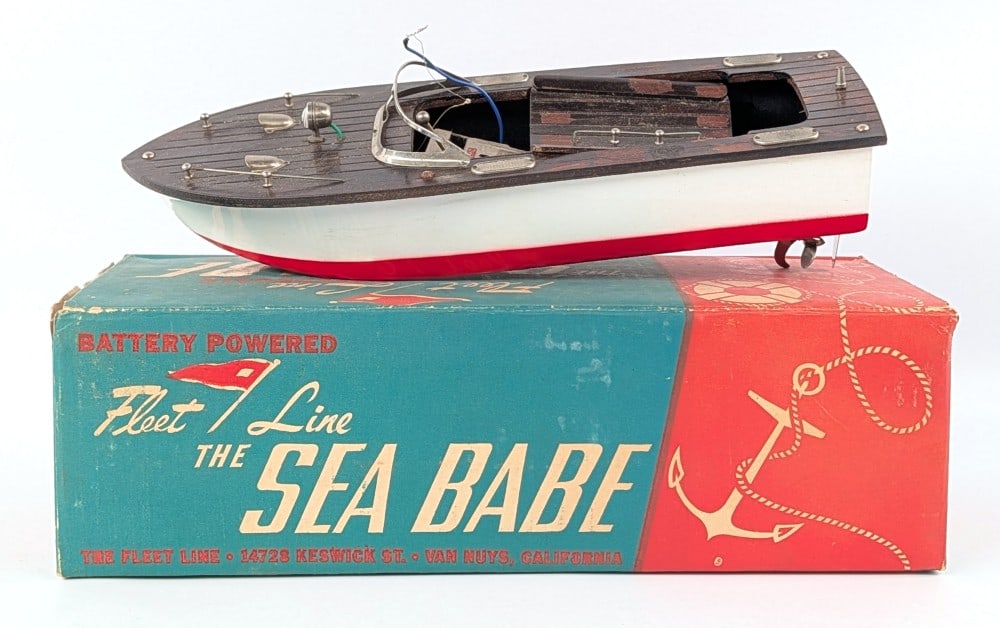 Fleet Line The Sea Babe Battery Operated Boat in Box: The Fleet Line Sea Babe battery operated toy boat in the original box. The boat is untested. The box has some moisture damage and wear from handling and age. Measures approximately 12-1/2" long.