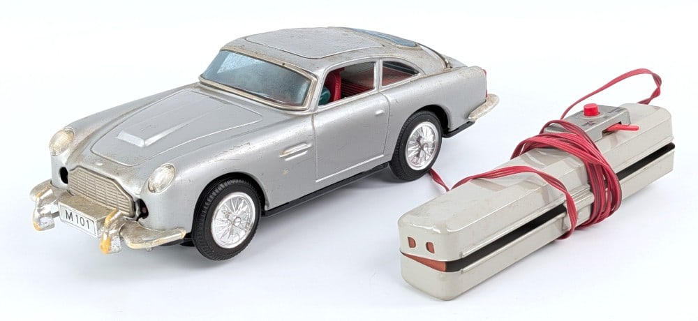 Japan Battery Op. Aston Martin James Bond Car: Japan tin battery operated Aston Martin James Bond car. The car shows some discoloration, scratches, and wear from play and age. Toy worked when tested. Measures approximately 11" across.?